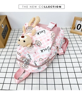 Détail d'un sac à dos en toile à carreaux roses avec tête d'ours en peluche et petite pochette