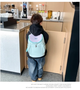 Rear view of a mint green and lavender kids backpack with drawstring side pockets