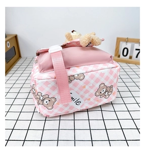 Détail du sac à dos enfant à carreaux roses avec un ours en peluche et une boucle en plastique