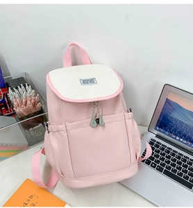 Detail view of pink colorblock backpack with buckle straps and durable nylon fabric