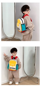 Detail of color-block canvas kids backpack showing fashion logo and side profile