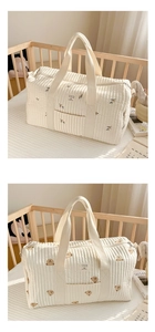 Close-up of quilted cotton mommy bag featuring olive and bear embroidery patterns
