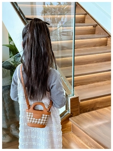 Toddler girl wearing vintage plaid mini handbag with brown leather strap on stairs