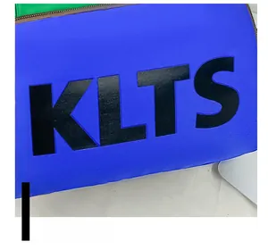 Detail of blue textured canvas bag featuring bold black KLTS lettering and brown zipper