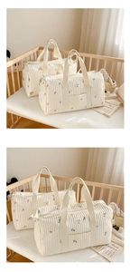 Quilted cotton diaper bags with floral and bear embroidery shown in a cozy nursery