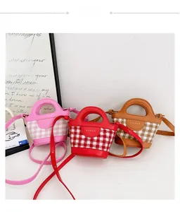 Detailed view of three mini plaid handbags in pink, red, and brown with Ma-har logo