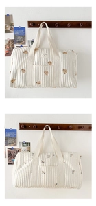 Detailed view of embroidered quilted travel bags featuring bear and olive motifs.