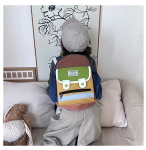 Detailed back view of a colorful patchwork kids backpack with retro fashion label
