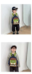 Detailed view of color-block canvas kids backpack with wide green adjustable straps