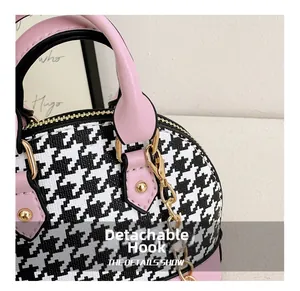 Detail of pink leather trim and houndstooth fabric with gold metal chain hooks