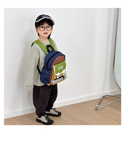 Detail of color-block canvas kids backpack with green straps and multi-pocket design