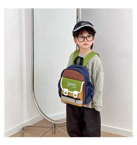 Detail of colorful canvas toddler backpack showing flap pocket and adjustable green straps
