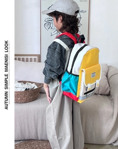 Detail of color-block canvas kids backpack with front pocket and fashion label