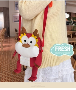 Détail d'un sac bandoulière dragon rouge en peluche avec sangle réglable dans un café