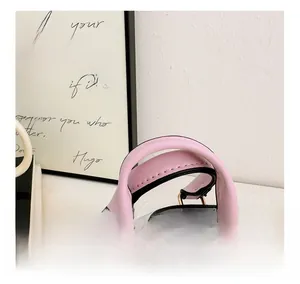 Detail of pink leather handle and black houndstooth fabric on kids mini shell bag