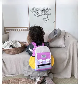 Rear view of a child wearing the colorful patchwork backpack in a cozy home setting