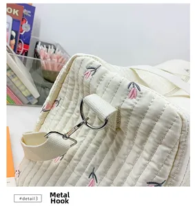 Close-up of silver metal swivel hook and D-ring on embroidered canvas baby bag