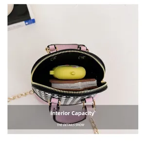 Internal capacity of mini houndstooth shell bag showing space for earbuds and cards