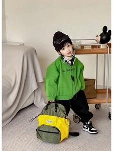 Détail d'un sac à dos enfant en nylon bicolore avec poche avant zippée et écusson