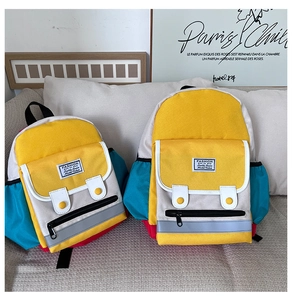 Detail of color-block kids backpacks in two sizes with reflective strips on sofa