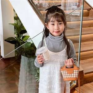 Fashionable girls mini checkered handbag styled with vintage grey top and white dress
