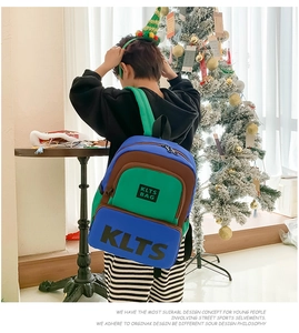 Detail of color-block kids backpack with KLTS lettering shown in a cozy festive setting
