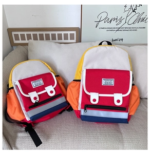 Size comparison of large and small color-block children backpacks on a sofa