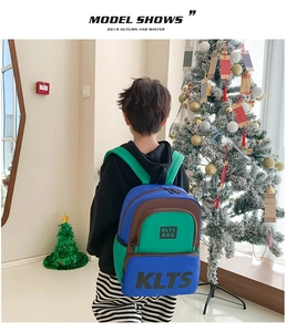 Detail view of a color-block kids backpack with KLTS logo in a festive holiday setting