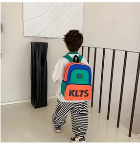 Detail of colorful contrast kids backpack with bold KLTS letters and wide straps