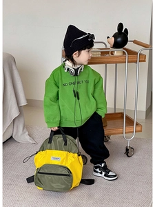 Détail d'un sac à dos enfant léger jaune et vert avec poche avant zippée fonctionnelle