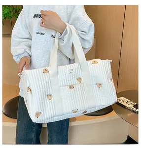 Detailed view of quilted white canvas bag with cute bear embroidery and sturdy handles