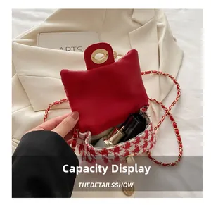Close-up of red houndstooth chain bag showing interior capacity with lipstick