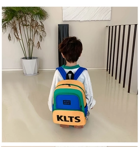 Rear view of child wearing colorful color-block school bag with KLTS lettering