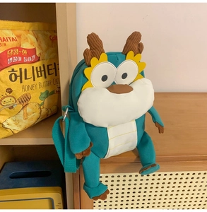 Détail du sac peluche dragon vert avec cornes en velours côtelé et bandoulière nylon