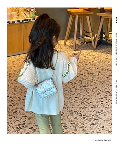 Silver quilted girls crossbody bag with metal chain shown on a child for fashion display