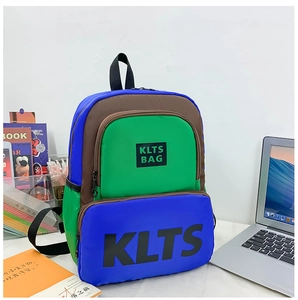 Detail of color-block kids backpack with KLTS letter print on white desk with books