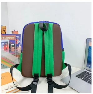 Detail of durable nylon backpack with thick green shoulder straps and blue fabric panels