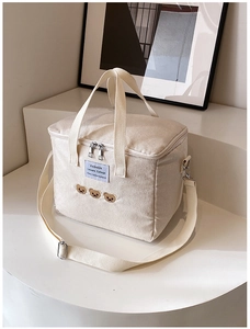 Detail of embroidered bear diaper bag showing canvas texture and adjustable shoulder strap
