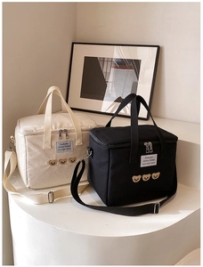 Detail of canvas diaper bag with embroidered teddy bears and adjustable shoulder straps
