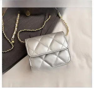 Macro detail of silver quilted mini crossbody bag with metallic chain and diamond pattern