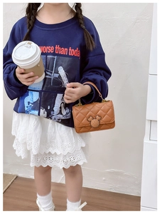 Détail d'un sac bandoulière marron matelassé pour fille avec boucle en métal Mickey