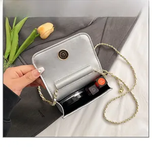 Detail view of silver mini crossbody bag capacity showing lipstick and compact inside