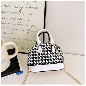 Detailed view of kids vintage shell handbag featuring a black and white houndstooth pattern