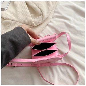 Detail of mini pink leather crossbody bag showing internal double compartments and strap