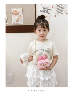 Detailed view of pink quilted cross-body bag with bow decoration on a young girl