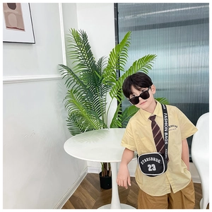Kids fashion nylon crossbody bag with STARSBRUG 23 print and yellow shirt outfit detail