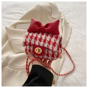 Close-up of red and white houndstooth mini bag with a large bow and gold twist lock