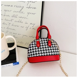 Detail of mini red and houndstooth dome bag with gold chain strap and dual handles