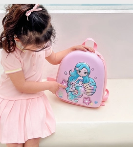 Detailed close-up of pink shell backpack featuring a 3D cartoon mermaid and sea motifs