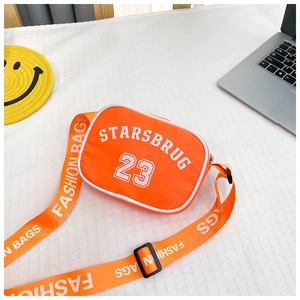 Detail of orange nylon kids crossbody bag featuring white varsity letters and wide strap